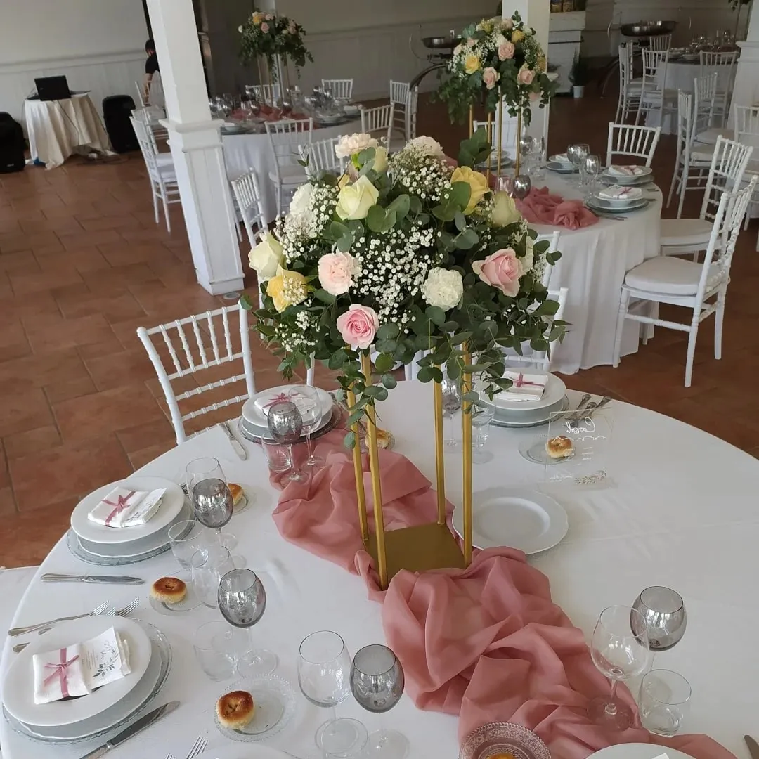 Centrotavola da matrimonio su alzata dorata con rose rosa, bianche e gialle e runner rosa